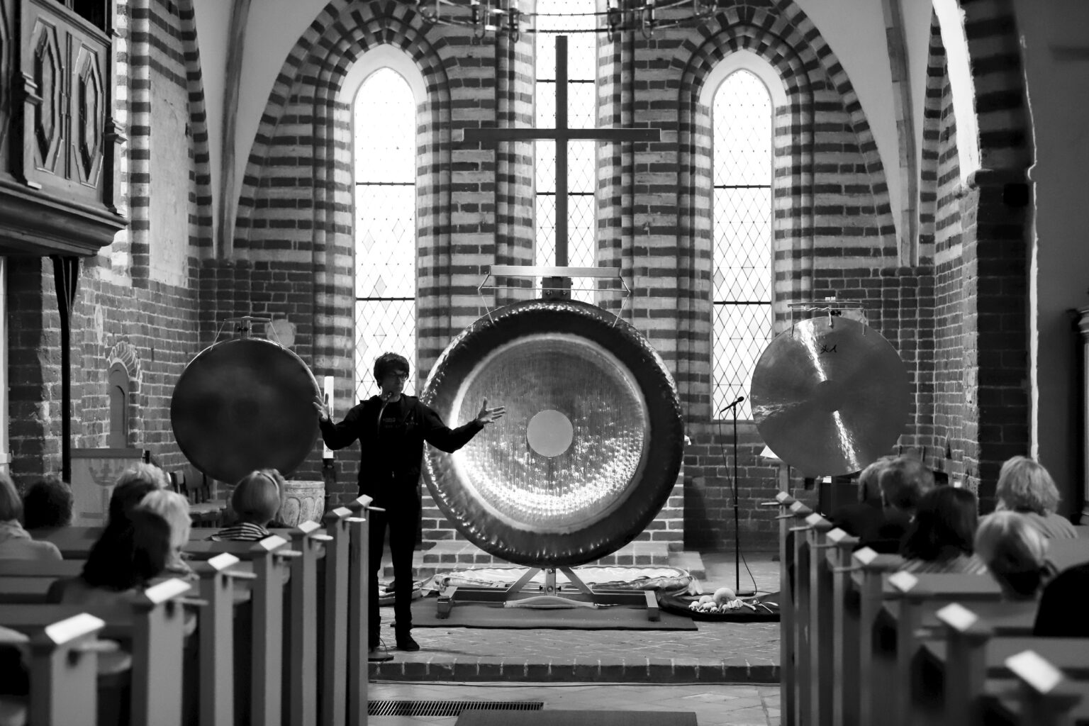Peter Heeren spielt große Gongs vor Publikum in einer Kirche